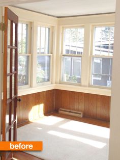 an empty room with wood paneling and windows