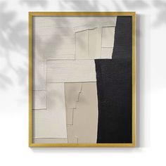 an abstract painting with black, white and grey colors on the wall above it is a gold frame