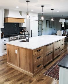 a large kitchen with an island in the middle and lots of cabinets on both sides