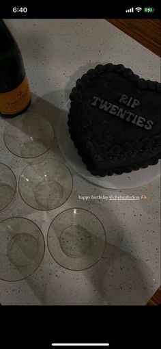 there is a cake on the table with wine glasses next to it and a bottle