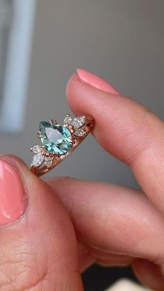 a woman's hand holding an engagement ring with blue and white stones