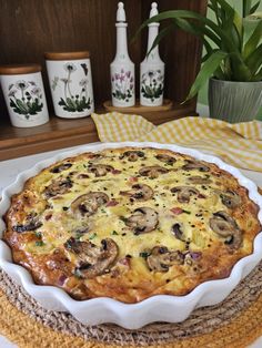 a pie sitting on top of a white plate next to a vase with flowers in it