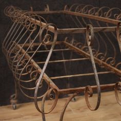 an old iron bed frame on a wooden floor