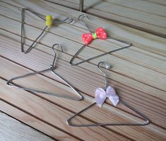 three metal hangers with bows on them sitting on a wooden floor next to each other