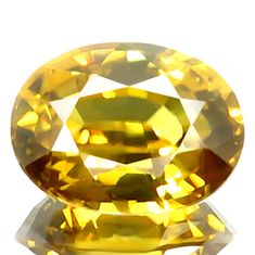 an oval yellow diamond sitting on top of a white surface