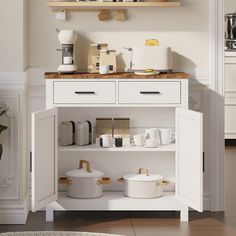 a kitchen with white cupboards and shelves filled with coffee pots, mugs and other items