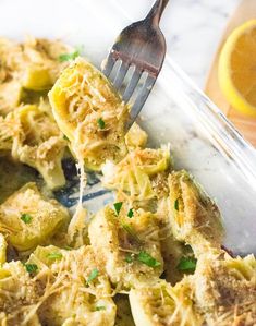 a fork is lifting up some food from a dish with broccoli florets