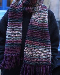 a woman wearing a purple and green scarf