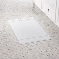 a white bathroom rug is on the floor