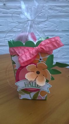 a paper bag with flowers on it sitting on a table