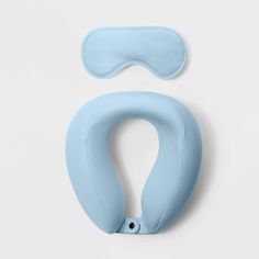 a blue eye mask and a sleeping mask on a white surface