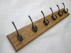 five hooks are attached to a wooden board