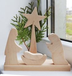 a wooden nativity scene sitting on a window sill