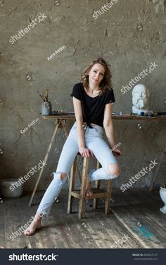 a woman sitting on top of a wooden stool