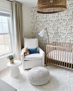 a baby's room with a crib, chair and ottoman