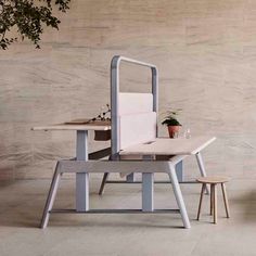 two chairs and a table in front of a wall with a potted plant on it