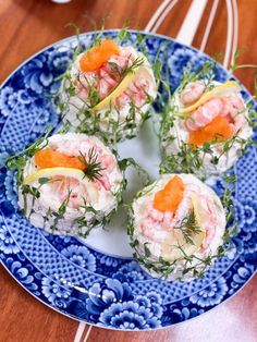 small appetizers are arranged on a blue and white plate with garnishes