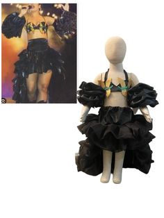 a mannequin with black ruffled skirt and gold necklace next to a photograph