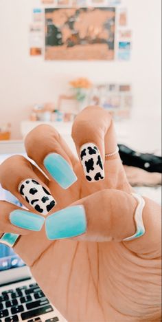 a woman's hand with blue and white nail polish