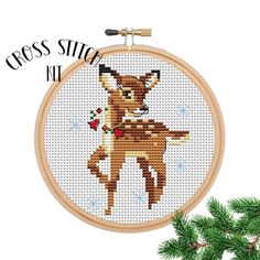 a cross stitch deer is hanging from a hoop