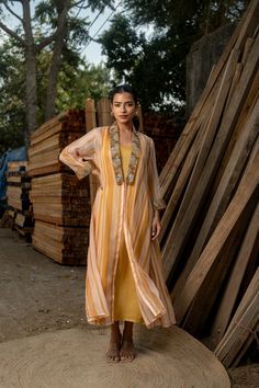 This stunning ensemble features a long-sleeve yellow gown paired with a matching jacket adorned with exquisite embroidery on the collar and sleeves. Perfect for Indian weddings or any special occasion, this readymade outfit offers versatility--you can wear the gown and jacket together for a coordinated look or opt for either piece alone to suit your style. Elegant and eye-catching, it's sure to make a statement at any party or event. Fabric - Orgenza, Georgette Satin Sleeve - Long Sleeves Work - Designer Front Open Dresses With Intricate Embroidery, Anarkali Dress With Dupatta And Front Open Style, Wedding Dresses With Intricate Embroidery And Front Open Design, Front Open Dress With Intricate Embroidery For Reception, Resham Embroidery Maxi Dress For Reception, Intricate Embroidery Front Open Dress For Reception, Designer Front Open Dress With Sheer Dupatta, Designer Wear Dress With Sheer Dupatta And Front Open, Embroidered Maxi Dress For Reception