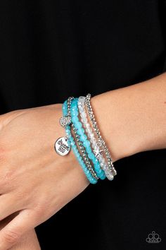 Reflective blue, defaced silver, reflective white, and smooth silver beads wrap around stretchy bands, and combine into a colorful stack along the wrist. The reflective, blue-beaded bracelet features a silver pendant with the phrase "dream BIG" stamped on it, while a defaced, silver-beaded bracelet features a silver star charm. Hanging from smooth, silver beads, a heart charm embossed with white rhinestones adds a shimmery detail to the stack, resulting in a youthful, dreamy design. Sold as one White Choker Necklace, Dreamy Design, White Choker, Orange Bracelet, Blue Charm, Blue Beaded Bracelets, Silver Necklace Set, Sparkle Necklace, Inspirational Bracelets