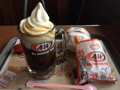 a hot chocolate drink with whipped cream on top and two packets of cookies next to it