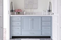 a bathroom with blue cabinets and marble counter tops