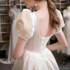 the back of a woman's dress with pearls on it