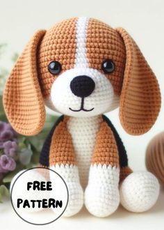 a crocheted stuffed dog sitting next to a purple and white flower bouquet with the text free pattern