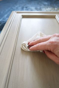 a person wiping the edges of a cabinet door with a microfil cloth on it