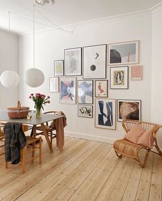 a dining room table with chairs and pictures on the wall