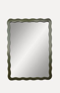 a square mirror with green trim around the edges