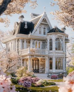 a large victorian style house surrounded by blooming trees