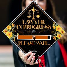 a woman holding up a graduation cap with the words, law in progress on it