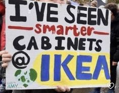 a person holding a sign that says i've seen smarter cabinets and ikea