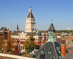 an old building with a clock tower in the middle of it's roof tops