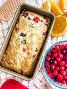 cranberry orange bread in a loaf pan next to fresh fruit