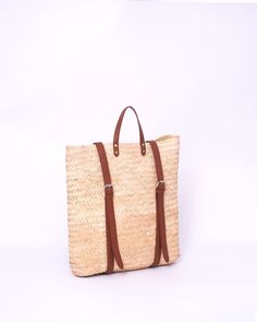 Do you want to look stylish and hippy? Get your hands on this handmade straw bag. It's high quality, eco-friendly, and handcrafted by women in Morocco. Its design is unique and timeless. Get yours now! we are proud to introduce our signature straw french bag to you. it is handmade by our talented artisan who has been working with us for years. this beautiful bag has a unique design that you would find nowhere else. the light and durable material are ideal for taking the bag on your adventures. Style is an important part of your life. The straw bag is a great way to spice up your look. You can either choose from our pre-made designs or customize the bag to your liking. Item's details: *Handmade in Morocco *Material: 100% Woven natural palm straw *Trim: 100% Vegan Leather Dimensions : Height Beige Straw Backpack For Travel, Brown Straw Backpack Bag For Travel, Brown Straw Backpack For Travel, Daily Use Straw Backpack, Summer Rectangular Backpack For Daily Use, Summer Rectangular Brown Backpack, Casual Natural Backpack For Vacation, Casual Natural-colored Backpack For Vacation, Casual Natural Color Backpack For Vacation