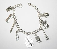 "This Artist charm bracelet is handcrafted using Rhodium Finished Nickle Free Cable Chain, 9 nickle free zinc alloy charms, Crayon Box Charm, Imagine Tag Charm, Paint Brush Charm, Paint Tube Charm, Artist Palette Charm, Art Easel Charm, Large Paint Brush Charm, Small Artist Palette with Brushes Charm, Artist Tool Mug Charm, Lobster Clasp *This bracelet measures approx 8 \" in length. You have the option to choose other bracelets sizes and also to add an initial charm When purchasing a bracelet f Adjustable Silver Charm Bracelet Costume Jewelry, Handmade Silver Bracelets For Gift, Artsy Silver Jewelry For Crafting, Adjustable Charms Bracelets For Gifts, Adjustable Charms Bracelets As Gifts, Artistic Bracelet Jewelry For Gift, Adjustable Charms Bracelet For Gift Making, Artistic Bracelet Jewelry Gift, Silver Bracelet Jewelry For Gift Making