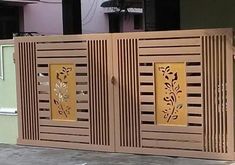 a wooden gate with decorative designs on the sides and side panels that are cut out to look like flowers