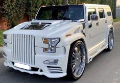 a white hummer is parked on the street