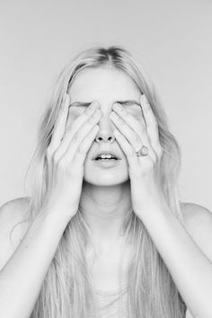 a woman covering her eyes with both hands