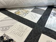 a close up of a quilt on a bed with writing on the back of it