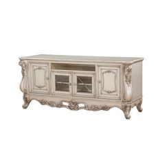 an antique style entertainment unit with glass doors and carvings on the front, in white