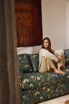 a woman sitting on top of a couch in a living room