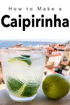 a glass filled with water and lime next to a lime on top of a table