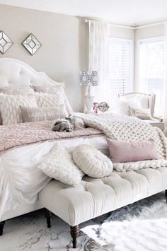 a white bed sitting in a bedroom next to a window