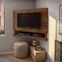 a flat screen tv mounted to the side of a wall above a small table and ottoman