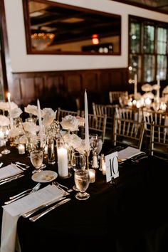 the tables are set with candles and place settings